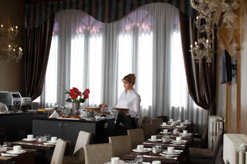 a woman standing in front of a dining room with tables at Arcadia Boutique Hotel in Venice