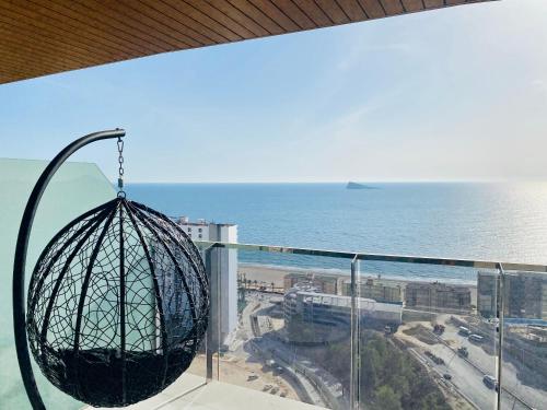 a view of the ocean from a balcony with a swing at Sunset Waves Benidorm by Mar Holidays in Benidorm