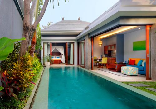 a swimming pool in front of a house at Seminyak Icon - by Karaniya Experience - CHSE certified in Seminyak