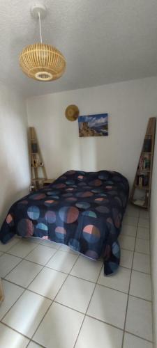 une chambre avec un lit et un lustre dans l'établissement Appt plage et soleil, à San-Nicolao