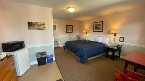 a hotel room with a bed and a tv at Bucksport Inn in Bucksport