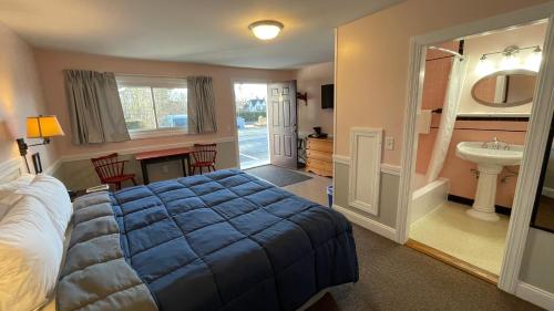 a bedroom with a bed and a bathroom with a sink at Bucksport Inn in Bucksport