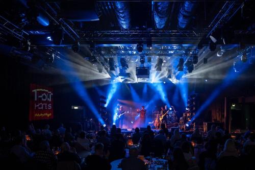 a stage with a band on it with blue lights at Thon Hotel Harstad in Harstad