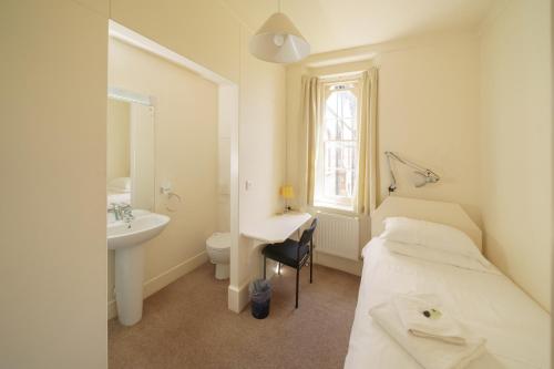 a bedroom with a bed and a sink and a toilet at Sarum College in Salisbury