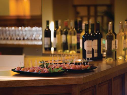 two plates of food on a counter with bottles of wine at Sarum College in Salisbury