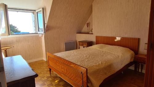 une petite chambre avec un lit et une fenêtre dans l'établissement Belle maison proche de la plage, quartier calme, Audierne / Esquibien, à Audierne