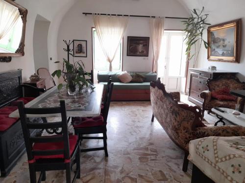 salon ze stołem, krzesłami i kanapą w obiekcie La Casa di Romeo w mieście Procida