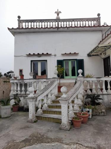 una casa blanca con escaleras delante en La Casa di Romeo en Procida