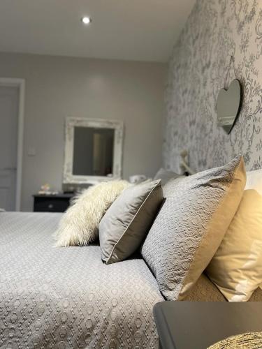 a bedroom with a bed with pillows and a television at Bricket House in Great Malvern