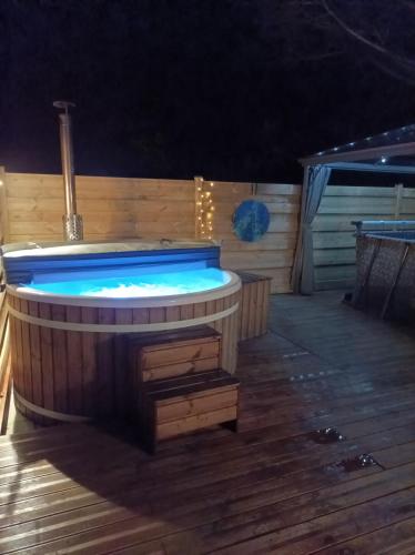 a large hot tub sitting on a wooden deck at Le Breil Furet in Ménéac