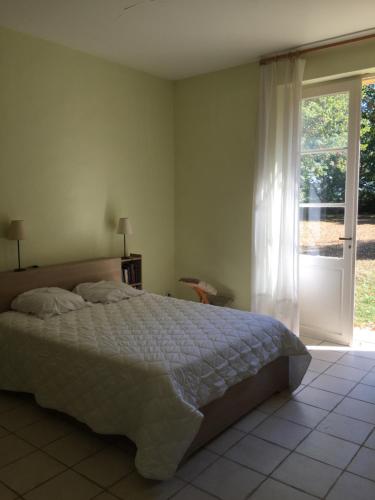 a bedroom with a bed and a sliding glass door at La Sabatière in Bergerac