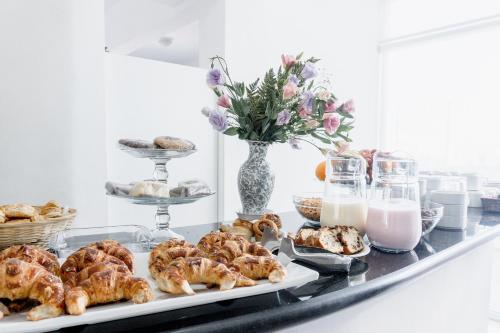 Una mesa con pasteles y leche sobre una mesa. en Mediterráneo Hotel y Spa, en Rosario