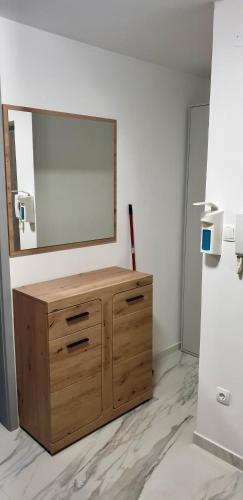 a wooden dresser with a mirror on a wall at Apartma Sivi žako in Bohinj
