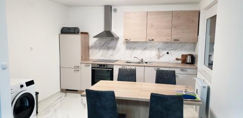 a kitchen with a table and chairs in a kitchen at Apartma Sivi žako in Bohinj