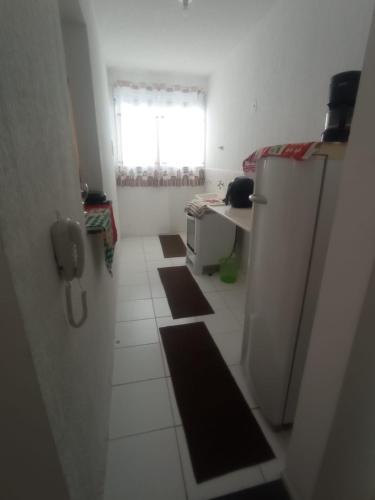 a small kitchen with a refrigerator and a window at Apto Agua Marinha in Campos dos Goytacazes