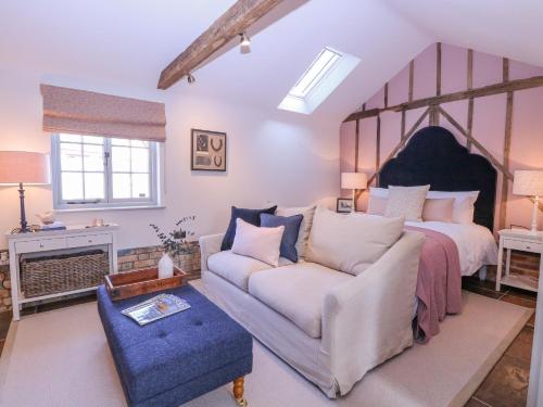 a bedroom with a large bed and a couch at The Forge in Stowmarket