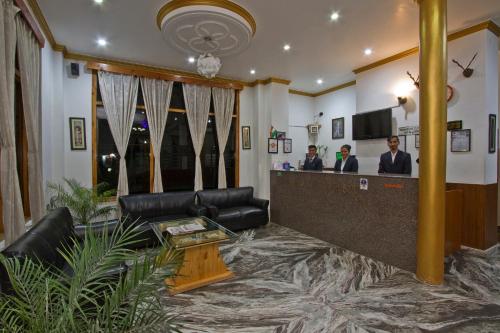 un vestíbulo con un bar con dos hombres en un salón en Hotel Rockland Inn, en Manali