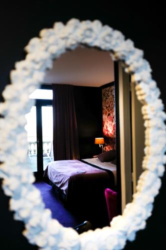 a mirror reflection of a bedroom with a bed in a room at Domaine De La Corniche in Rolleboise