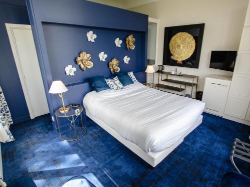 a bedroom with a large bed with blue walls at Domaine De La Corniche in Rolleboise