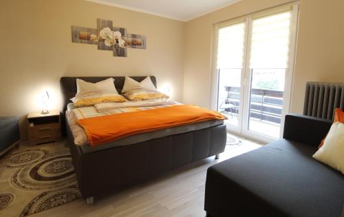 a bedroom with a bed with an orange blanket at FABIAN - Ski und Thermen Appartement in Bach
