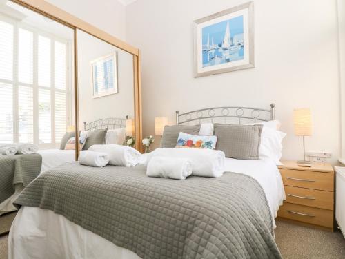 a bedroom with two beds with pillows on them at By The Sea in Newquay