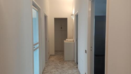 バーリにあるApple guest houseの廊下、洗面台付きのバスルーム、窓が備わります。