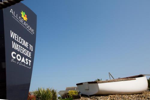 a boat sitting on the beach next to a sign at Allseasons Hotel in Lowestoft