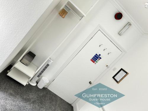 a white door in a room with a tv at Gumfreston Guest House in Tenby