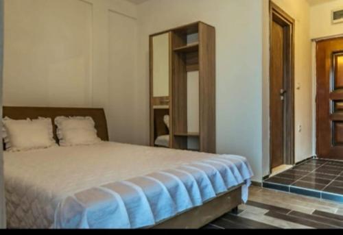 um quarto com uma cama grande e um espelho em Apartmani Maša em Budva