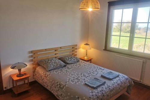 une chambre avec un lit avec deux oreillers dessus dans l'établissement Escapade en famille à Plougasnou - Finistère, à Plougasnou