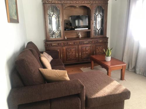 a living room with a couch and a tv at Casinha da Vila in Arcos de Valdevez