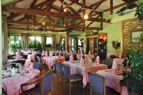 une salle remplie de tables et de chaises avec des nappes roses dans l'établissement Hotel Restaurant La Tour Romaine - Haguenau - Strasbourg Nord, à Schweighouse-sur-Moder
