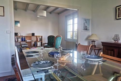 une salle à manger avec une table et des chaises en verre dans l'établissement Escapade en famille à Plougasnou - Finistère, à Plougasnou