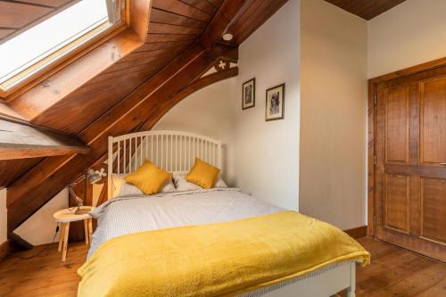 ein Schlafzimmer mit einem Bett mit gelber Bettwäsche und einem Fenster in der Unterkunft The Nave - Norfolk Holiday Properties in Gorleston-on-Sea