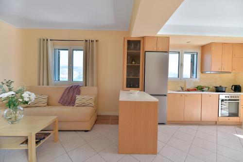 a living room with a couch and a kitchen at Villa Reverenza in Lixouri