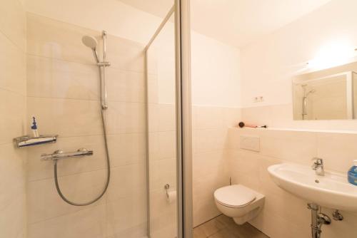 a bathroom with a shower and a toilet and a sink at Haus Albatros Wohnung Nr.8 in Norderney