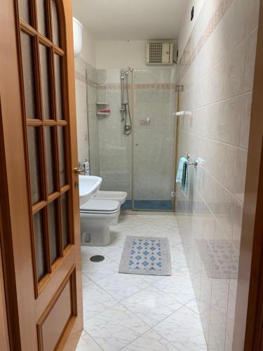 a bathroom with a shower and a toilet and a glass door at DONNA CONCETTA HOUSE in Ravello