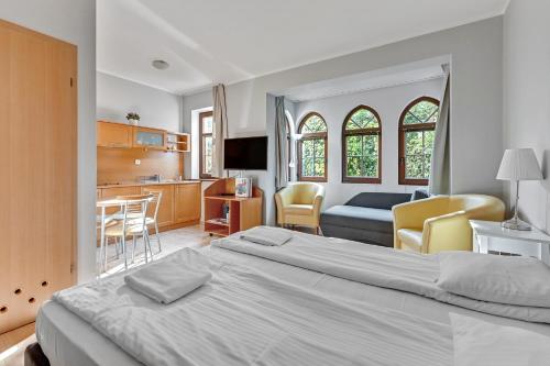 a bedroom with a large bed and a kitchen at Dom & House - Apartamenty Zacisze in Sopot
