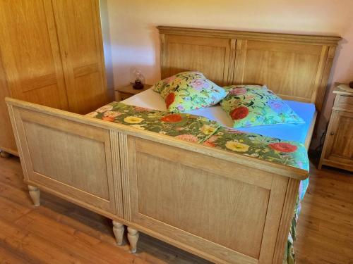 ein Schlafzimmer mit einem Holzbett mit zwei Kissen in der Unterkunft Kellerstöckl Weber in Güssing