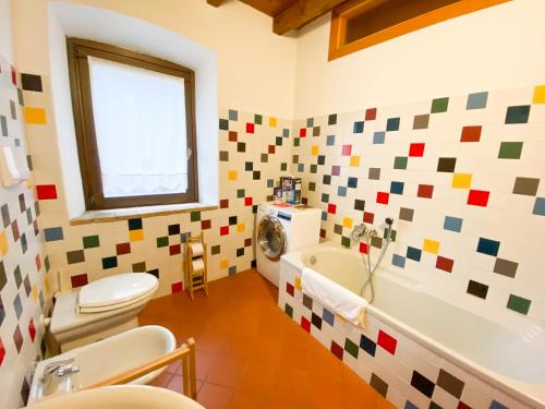 y baño con aseo, bañera y lavamanos. en Casa Vacanze di Arlecchino, en San Giovanni Bianco