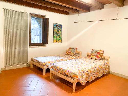 een slaapkamer met 2 bedden en een raam bij Casa Vacanze di Arlecchino in San Giovanni Bianco