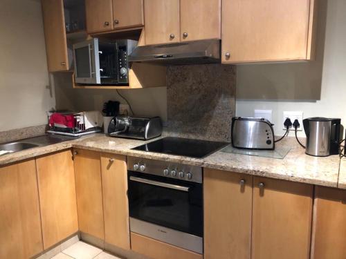 a kitchen with wooden cabinets and a stove top oven at Mystique No 9 in Shelly Beach