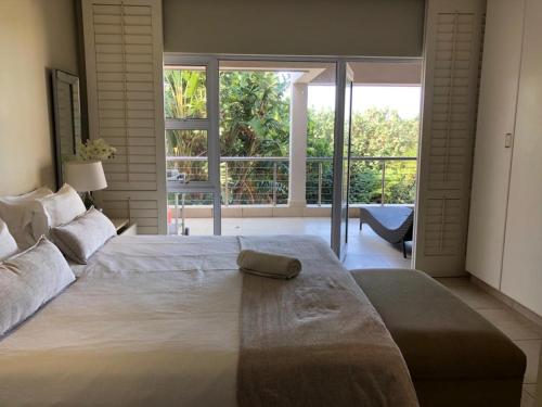 a large bed in a bedroom with a large window at Mystique No 9 in Shelly Beach