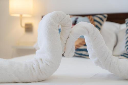 a towel animal shaped like a heart on a bed at Stella Maris Marzamemi Apartments in Marzamemi