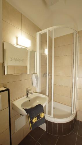 a white bathroom with a sink and a shower at Westend City Hostel in Vienna