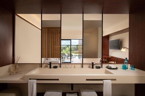 a bathroom with a sink and a large mirror at Live Aqua Beach Resort Punta Cana - All Inclusive - Adults Only in Punta Cana