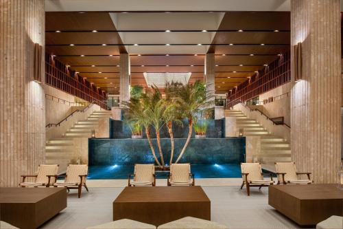 a lobby with stairs and chairs and a palm tree at Live Aqua Beach Resort Punta Cana - All Inclusive - Adults Only in Punta Cana
