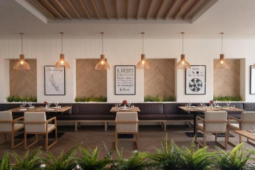 a restaurant with tables and chairs and pendant lights at Live Aqua Punta Cana - All Inclusive - Adults Only in Punta Cana