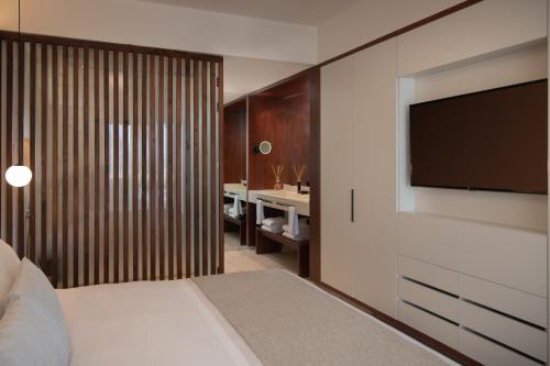 a bedroom with a bed and a flat screen tv at Live Aqua Punta Cana - All Inclusive - Adults Only in Punta Cana