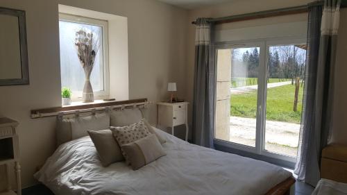 une chambre avec un lit blanc avec une fenêtre dans l'établissement Gites des Casernes, à Saint-Christophe